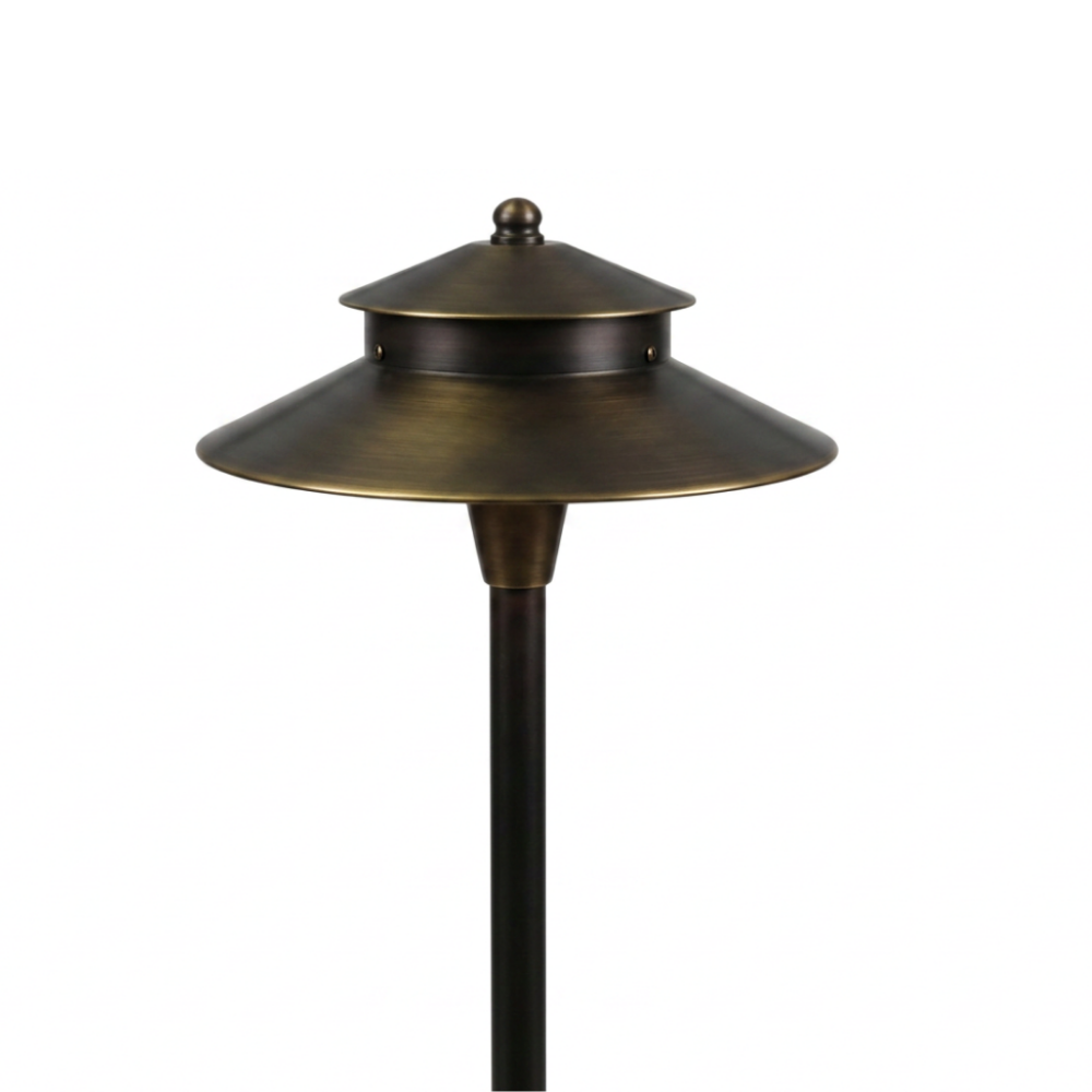 Two-tier solid brass path light illuminating a garden walkway with warm LED lighting, providing durable and elegant landscape pathway illumination.